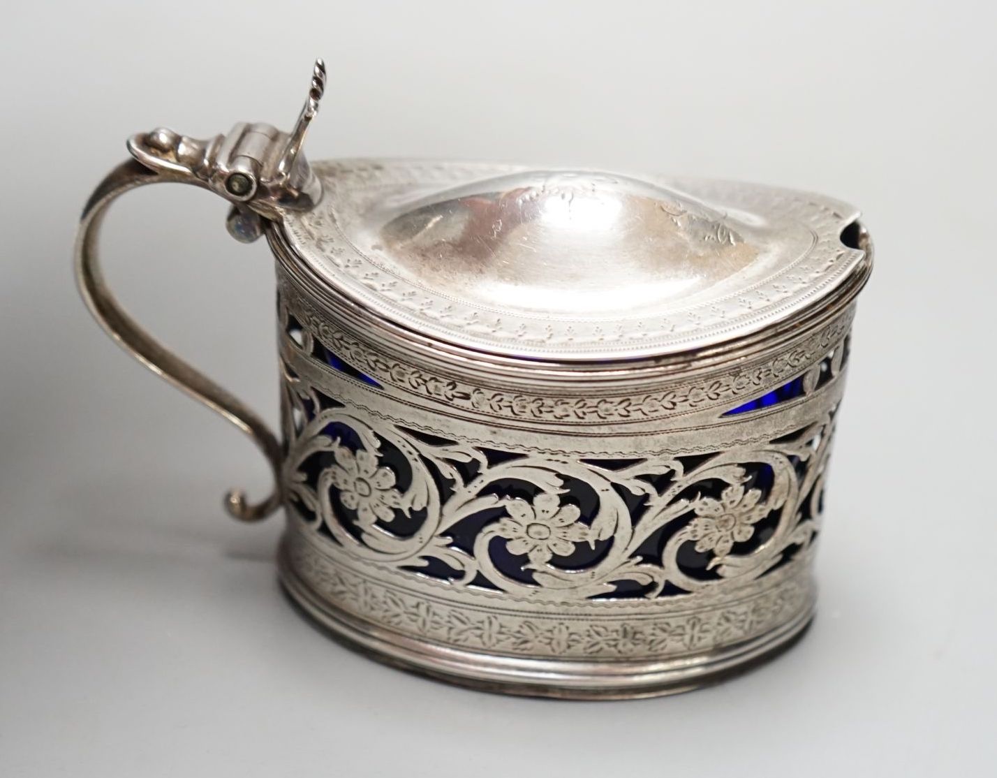 A George III engraved and pierced silver oval mustard pot, Michael Plummer, London, 1793, length 10cm.